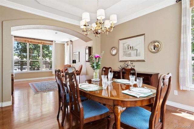 5120 Langdale Way, Colorado Springs, CO 80906 - dining space with light wood-style floors, a chandelier, arched walkways, and crown molding