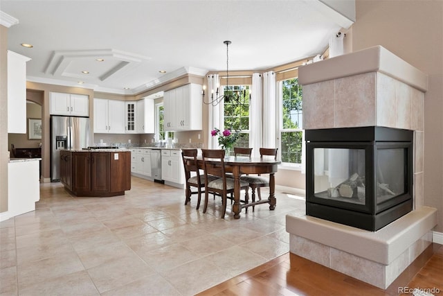 5120 Langdale Way, Colorado Springs, CO 80906 - kitchen featuring appliances with stainless steel finishes, white cabinetry, glass insert cabinets, ornamental molding, and a kitchen island