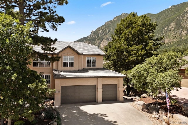 5120 Langdale Way, Colorado Springs, CO 80906 - view of front of house featuring a garage, a mountain view, concrete driveway, stucco siding, and a tile roof