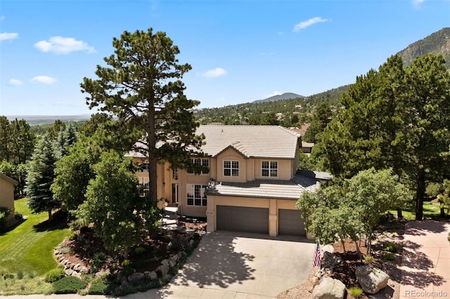 5120 Langdale Way, Colorado Springs, CO 80906 - traditional-style house featuring driveway, an attached garage, a mountain view, stucco siding, and a tiled roof