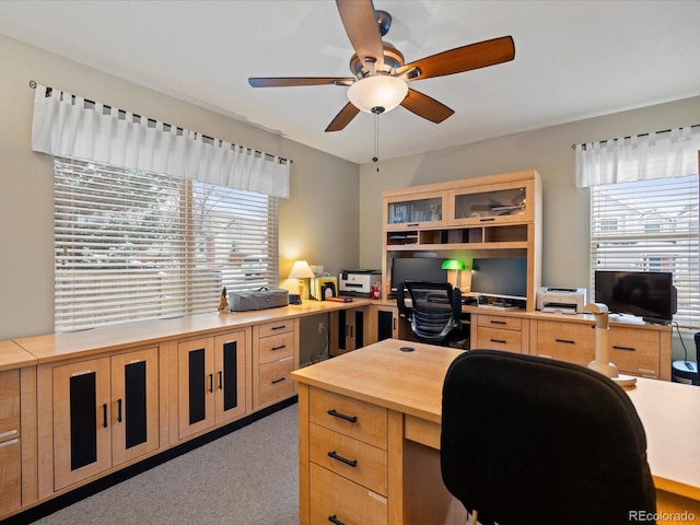 carpeted home office featuring ceiling fan