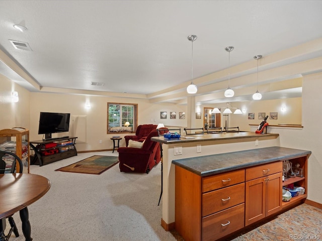 kitchen featuring pendant lighting, a breakfast bar area, and light colored carpet