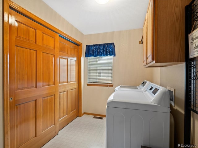 washroom featuring cabinets and washing machine and dryer