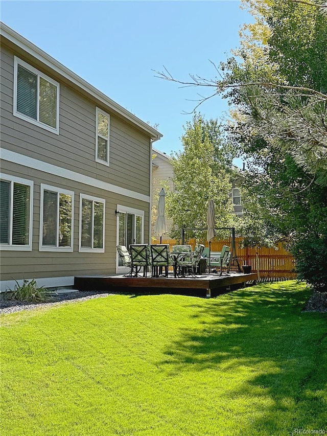 back of house featuring a wooden deck and a yard