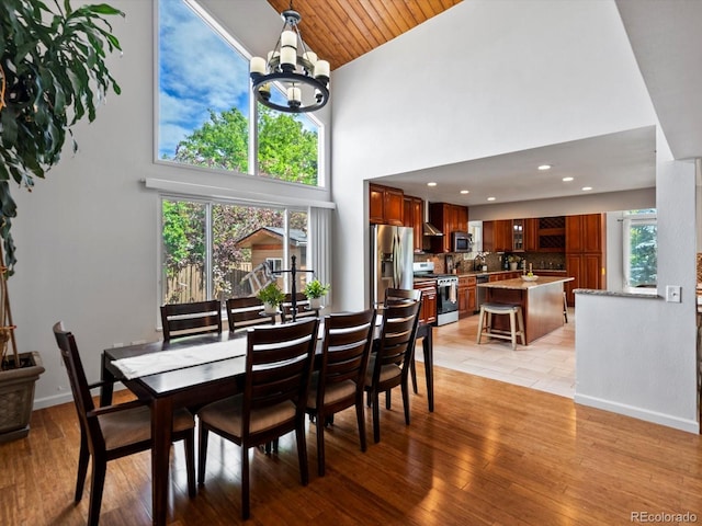 5884 S Hanover Way, Greenwood Village, CO 80111 - dining room with high vaulted ceiling, a chandelier, light wood finished floors, and baseboards