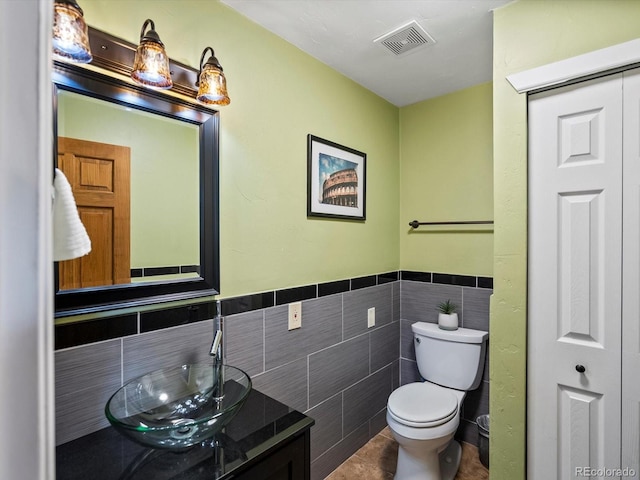 5884 S Hanover Way, Greenwood Village, CO 80111 - bathroom featuring toilet, vanity, tile walls, a closet, and wainscoting