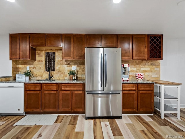 5884 S Hanover Way, Greenwood Village, CO 80111 - kitchen featuring freestanding refrigerator, dishwasher, a sink, decorative backsplash, and light wood-type flooring