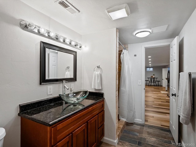 5884 S Hanover Way, Greenwood Village, CO 80111 - full bath with wood finished floors, vanity, a shower stall, and baseboards