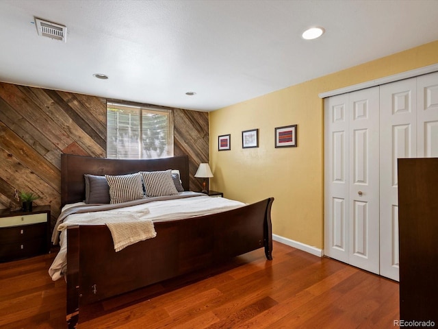 5884 S Hanover Way, Greenwood Village, CO 80111 - bedroom with wood walls, wood finished floors, baseboards, a closet, and recessed lighting