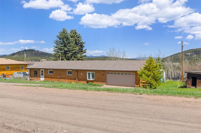 26063 Morris Ave, Conifer, CO 80433 - view of front of home with a mountain view, an attached garage, and driveway
