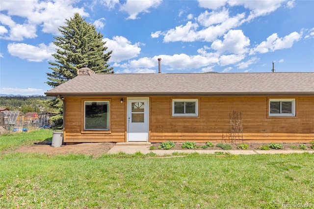 26063 Morris Ave, Conifer, CO 80433 - view of front of property with a front lawn, roof with shingles, and a chimney