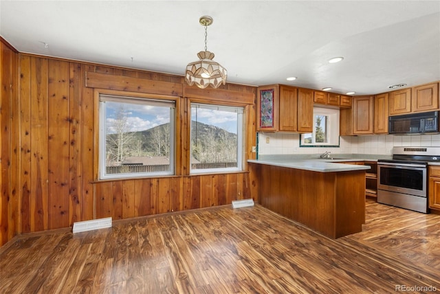 26063 Morris Ave, Conifer, CO 80433 - kitchen with black microwave, stainless steel electric range, brown cabinetry, a peninsula, and wood finished floors