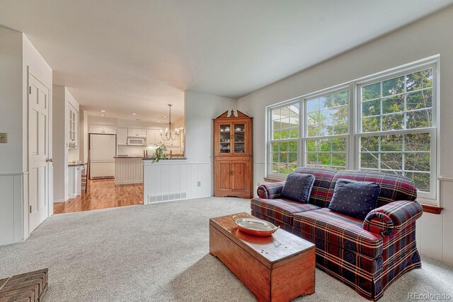 7100 S Hudson Cir, Centennial, CO 80122 - living room featuring visible vents, a decorative wall, a chandelier, and light carpet