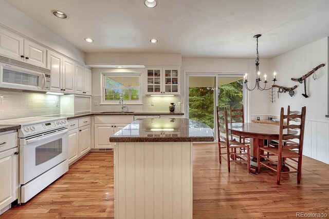 7100 S Hudson Cir, Centennial, CO 80122 - kitchen with a sink, a chandelier, light wood-style floors, white appliances, and white cabinetry