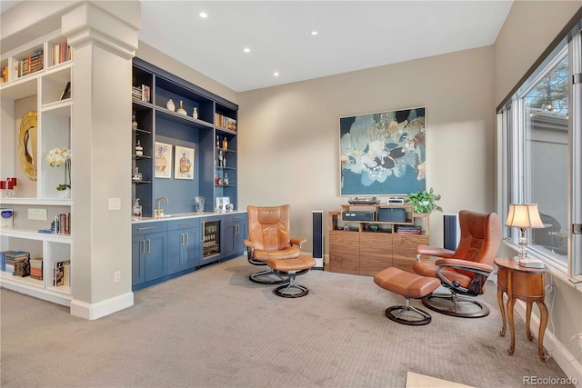 sitting room featuring recessed lighting, beverage cooler, light colored carpet, and indoor wet bar