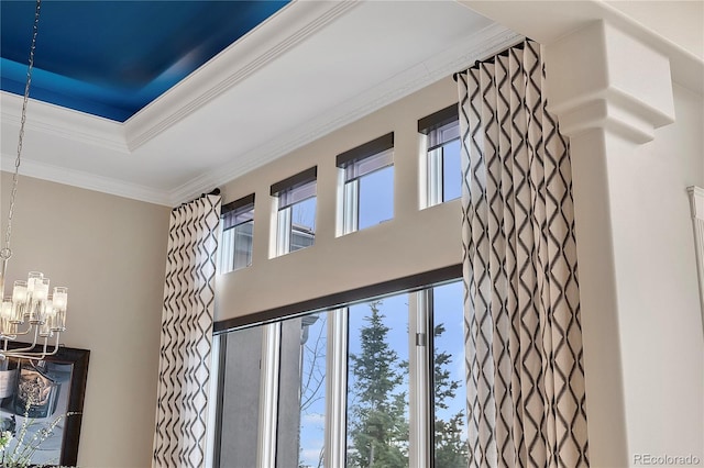 details with a tray ceiling, an inviting chandelier, and crown molding