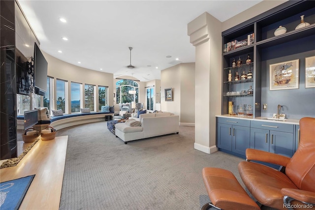 living area with light carpet, wet bar, baseboards, and recessed lighting