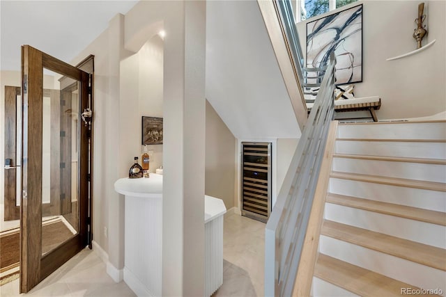 staircase with tile patterned flooring, baseboards, and beverage cooler