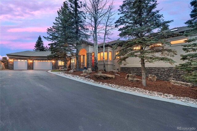 814 Neville Ln, Golden, CO 80401 - view of front facade featuring asphalt driveway, an attached garage, and stucco siding