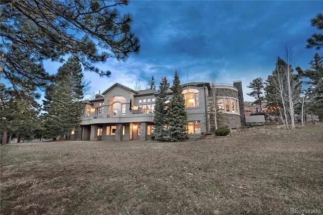 814 Neville Ln, Golden, CO 80401 - back of house featuring a balcony, stone siding, and a lawn