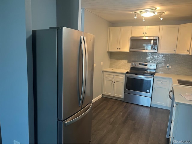 kitchen featuring light countertops, decorative backsplash, appliances with stainless steel finishes, dark wood-type flooring, and white cabinets