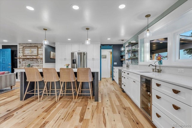 kitchen with wine cooler, appliances with stainless steel finishes, and hanging light fixtures