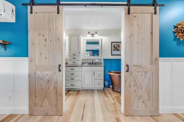 bathroom with vanity, a bath, and hardwood / wood-style flooring