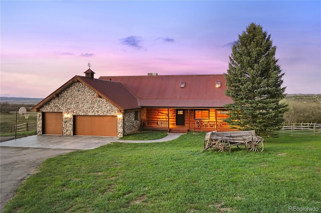 view of front of home featuring a lawn, stone siding, driveway, and fence