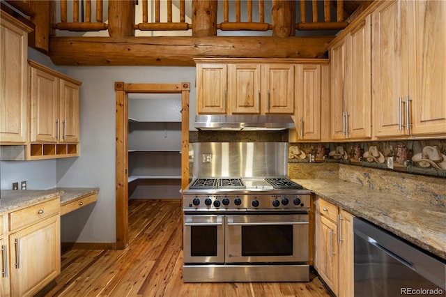 kitchen with light wood-type flooring, backsplash, under cabinet range hood, appliances with stainless steel finishes, and light stone counters