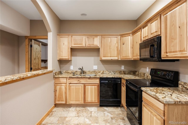 kitchen featuring a sink, light brown cabinetry, baseboards, arched walkways, and black appliances
