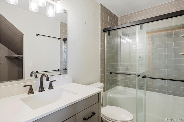 full bathroom featuring a shower stall, vanity, toilet, and a textured wall