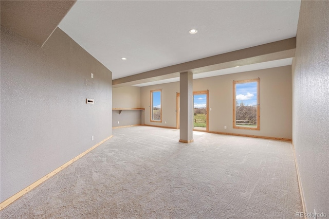 basement with carpet floors, baseboards, a healthy amount of sunlight, and recessed lighting