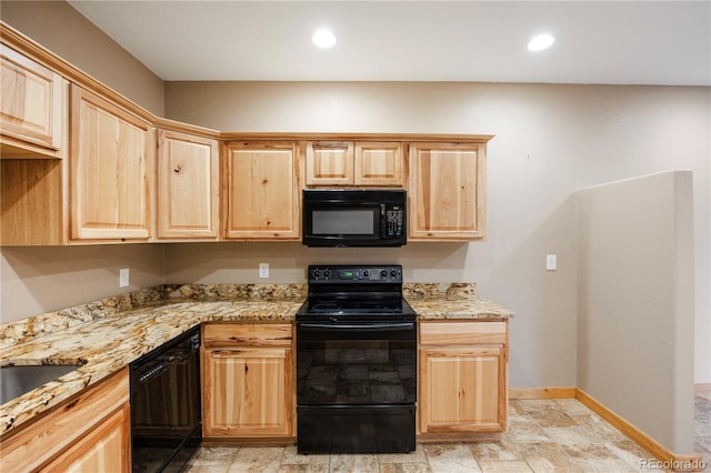 kitchen featuring light brown cabinets, stone finish floor, baseboards, black appliances, and light stone counters
