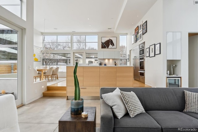 living area with beverage cooler and a high ceiling