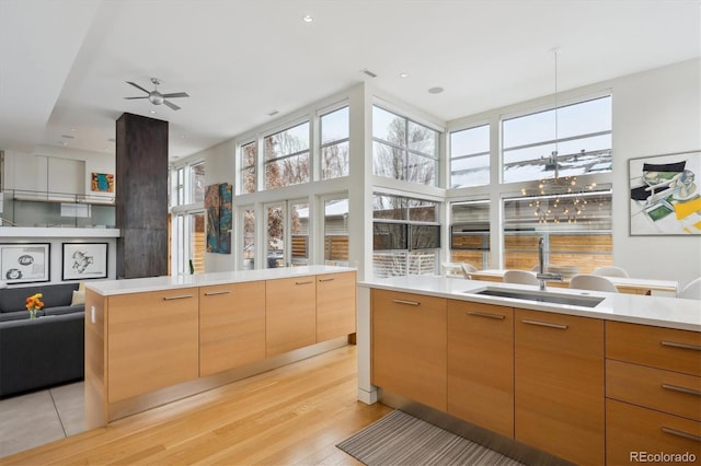 kitchen with light wood-type flooring, modern cabinets, light countertops, and open floor plan