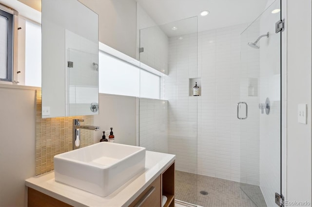 full bathroom featuring a shower stall, vanity, and decorative backsplash