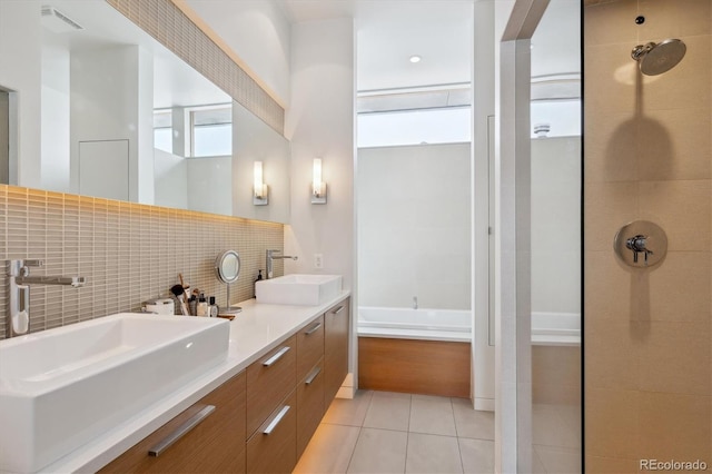 bathroom featuring visible vents, a tile shower, a sink, and tile patterned floors