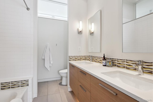 full bathroom featuring double vanity, tile patterned flooring, a sink, and toilet