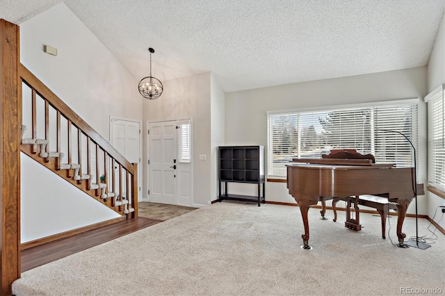 foyer featuring stairs, carpet flooring, plenty of natural light, and a textured ceiling