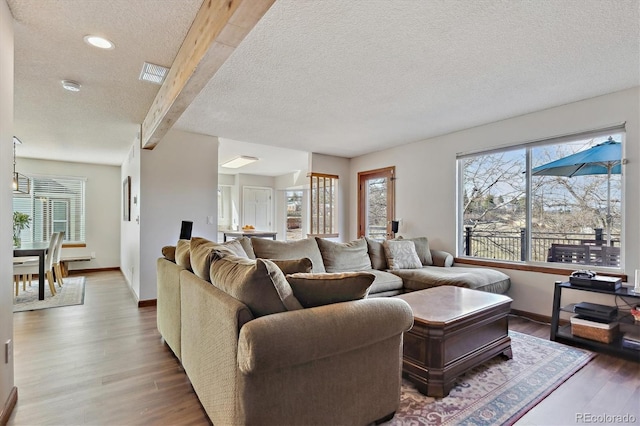 living area with visible vents, a healthy amount of sunlight, and wood finished floors