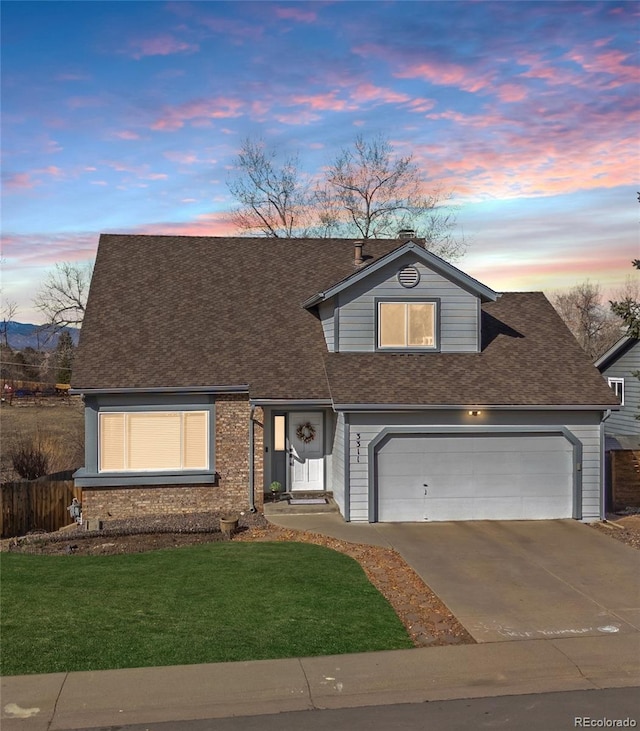 traditional-style house with a yard, driveway, and a shingled roof