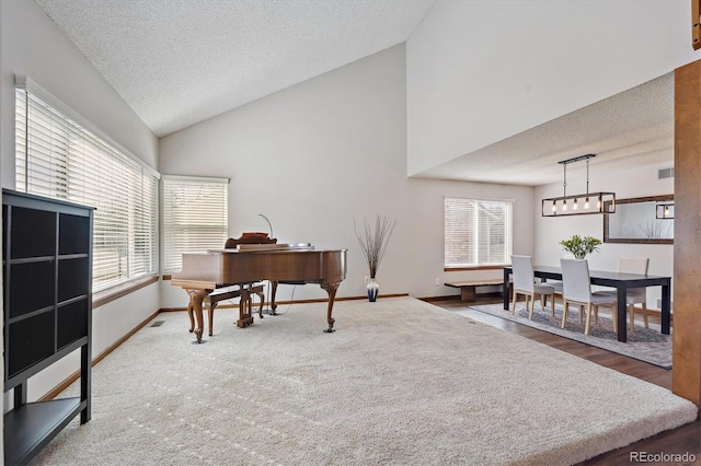 carpeted office space featuring visible vents, a textured ceiling, baseboards, and high vaulted ceiling