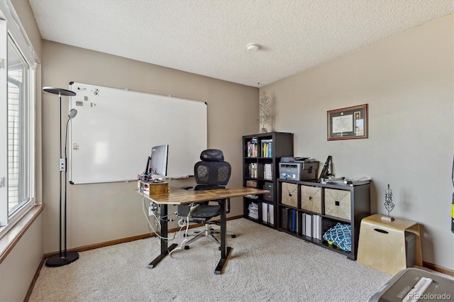 carpeted office featuring baseboards and a textured ceiling