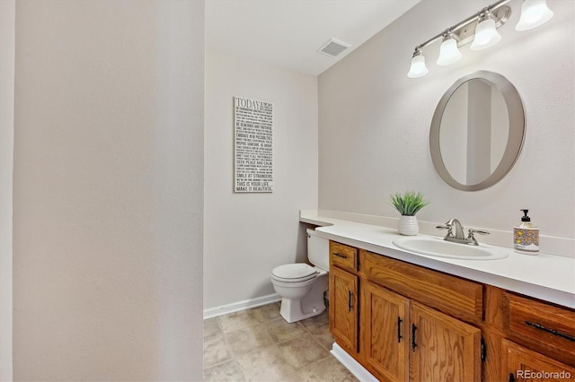 bathroom featuring visible vents, baseboards, toilet, and vanity