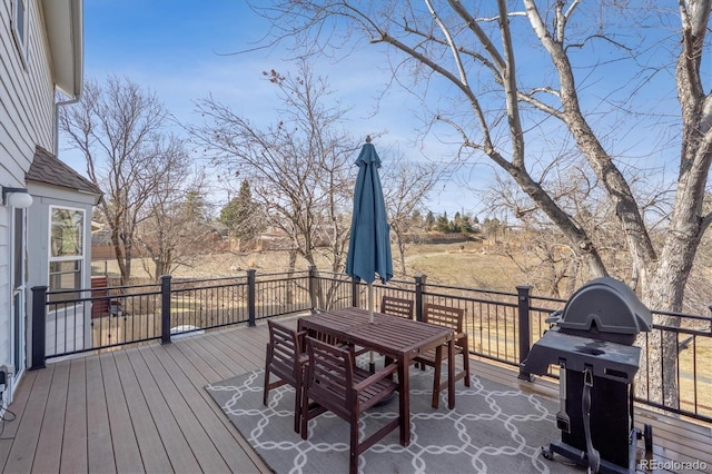 wooden deck featuring outdoor dining area and a grill