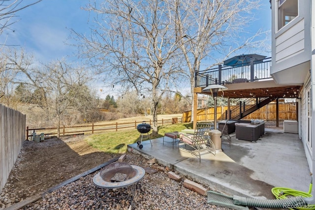 view of yard with an outdoor living space with a fire pit, stairway, a wooden deck, a fenced backyard, and a patio