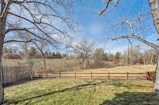 view of yard with a rural view and fence