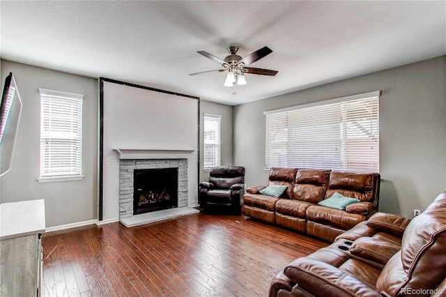 25046 E Bayaud Pl, Aurora, CO 80018 - living room featuring a ceiling fan, hardwood / wood-style flooring, a stone fireplace, and baseboards