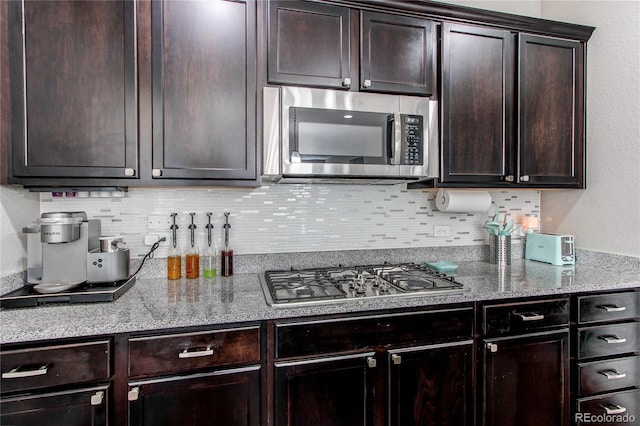 25046 E Bayaud Pl, Aurora, CO 80018 - kitchen with appliances with stainless steel finishes, backsplash, and dark brown cabinetry