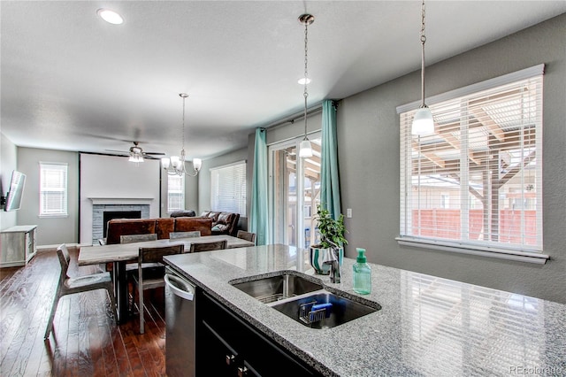 25046 E Bayaud Pl, Aurora, CO 80018 - kitchen with a fireplace, dishwasher, dark wood finished floors, ceiling fan, and pendant lighting